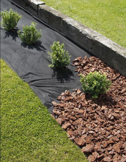 Landscape fabric beneath decorative bark and stone