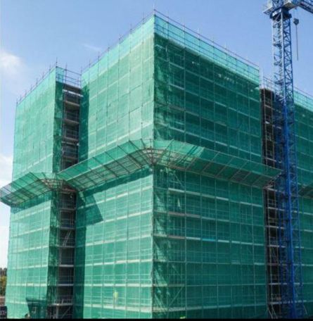 Scaffold netting on a building under construction with a crane